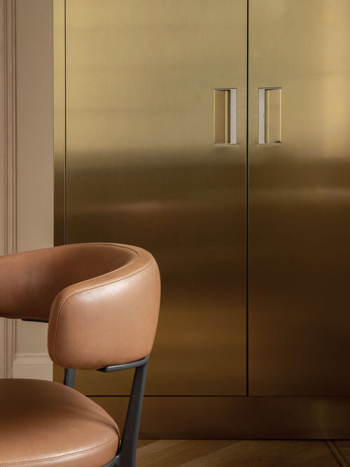 Arclinea Convivium kitchen, Convivium Elegant door in Champagne PVD stainless steel and worktop in marble. Convivio table in natural oak and Caratos chairs in Kasia leather 