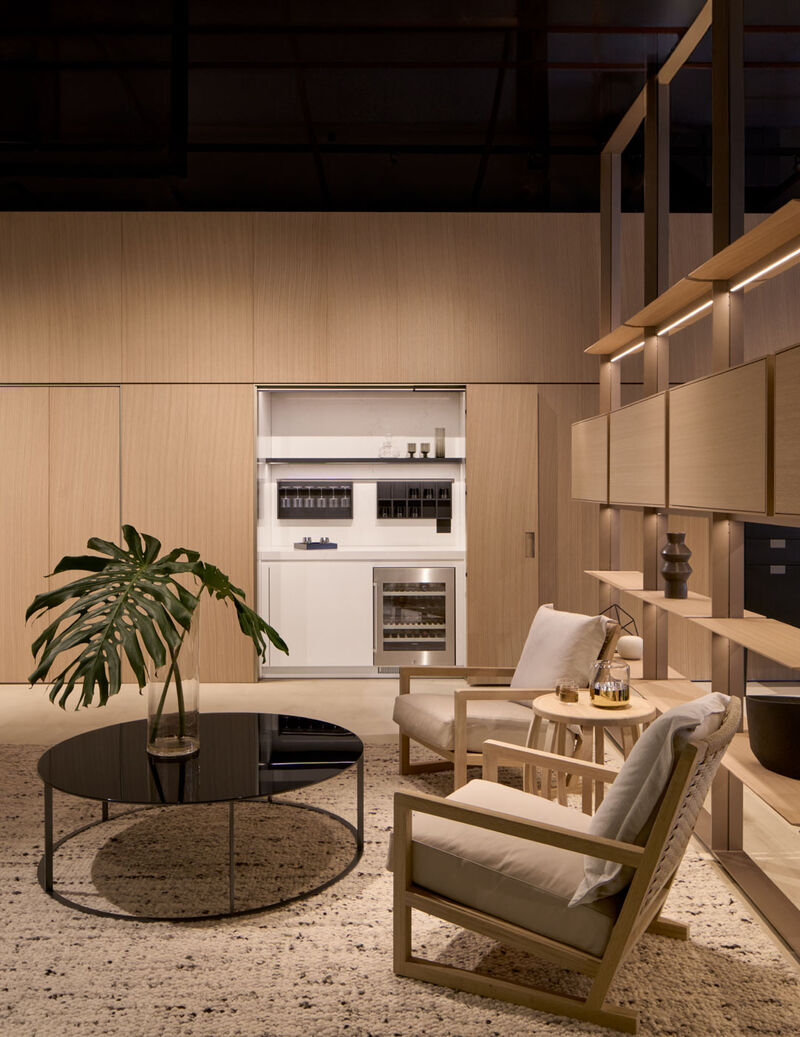 Arclinea Thea kitchen open living area with lounge seating, shelving and hidden kitchen unit
