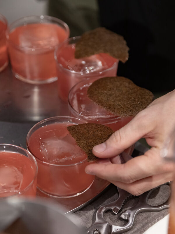 Crispy garnish placed on pink cocktails at Arclinea MDW22 event