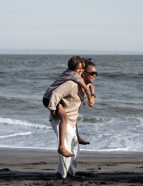 Aleandro playing with his kid in front of the sea