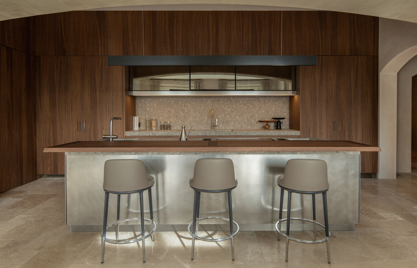Arclinea kitchen Convivium with metal island, bar stools, and full-height wood storage wall