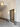 Grand corridor with ornate plaster mouldings, a lantern-style pendant light, a black-framed glass door, and grey stone flooring