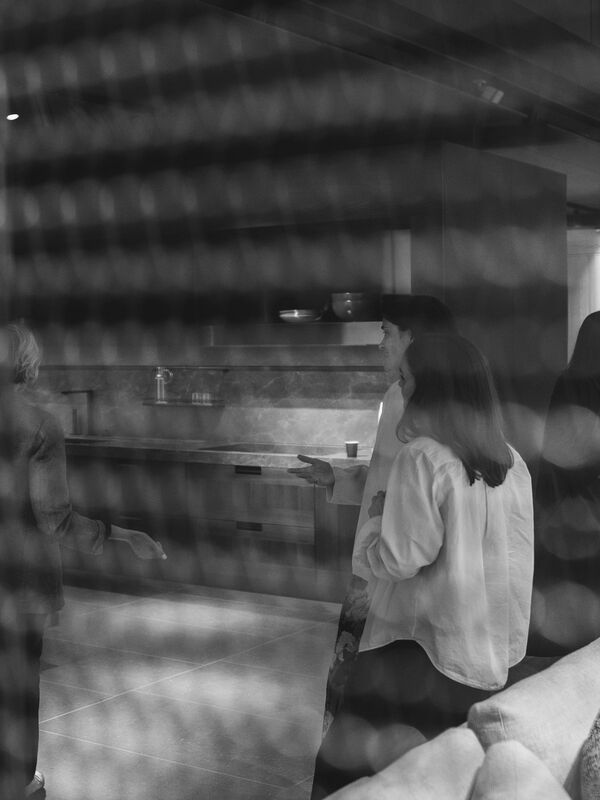 Guests viewed through perforated screen in Arclinea kitchen showroom