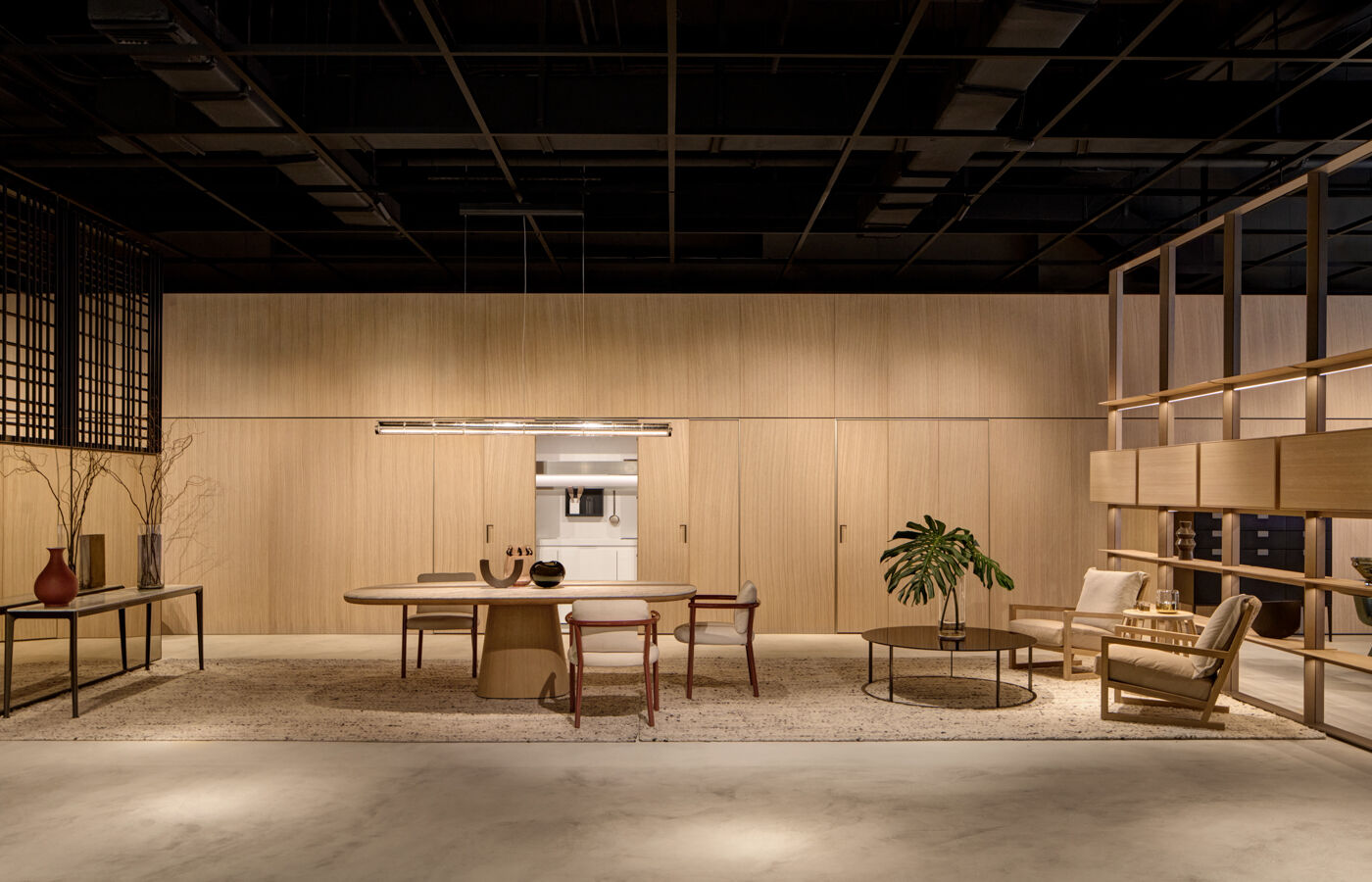 Arclinea Thea kitchen with concealed doors, wood wall and integrated dining and lounge area
