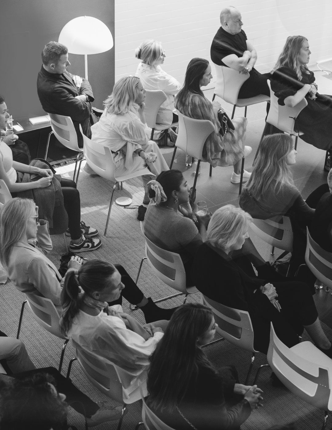 Guests seated in rows of chairs attentively follow a talk during the Brompton Road showroom opening event