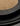Close-up of grain scattered on a dark textured plate, stacked atop matching ridged black plates