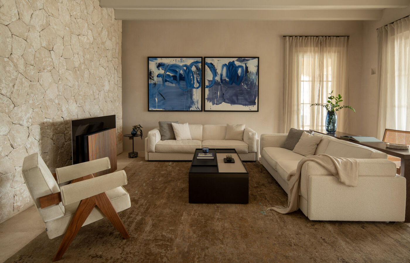 open-plan living area with stone wall and neutral sofas