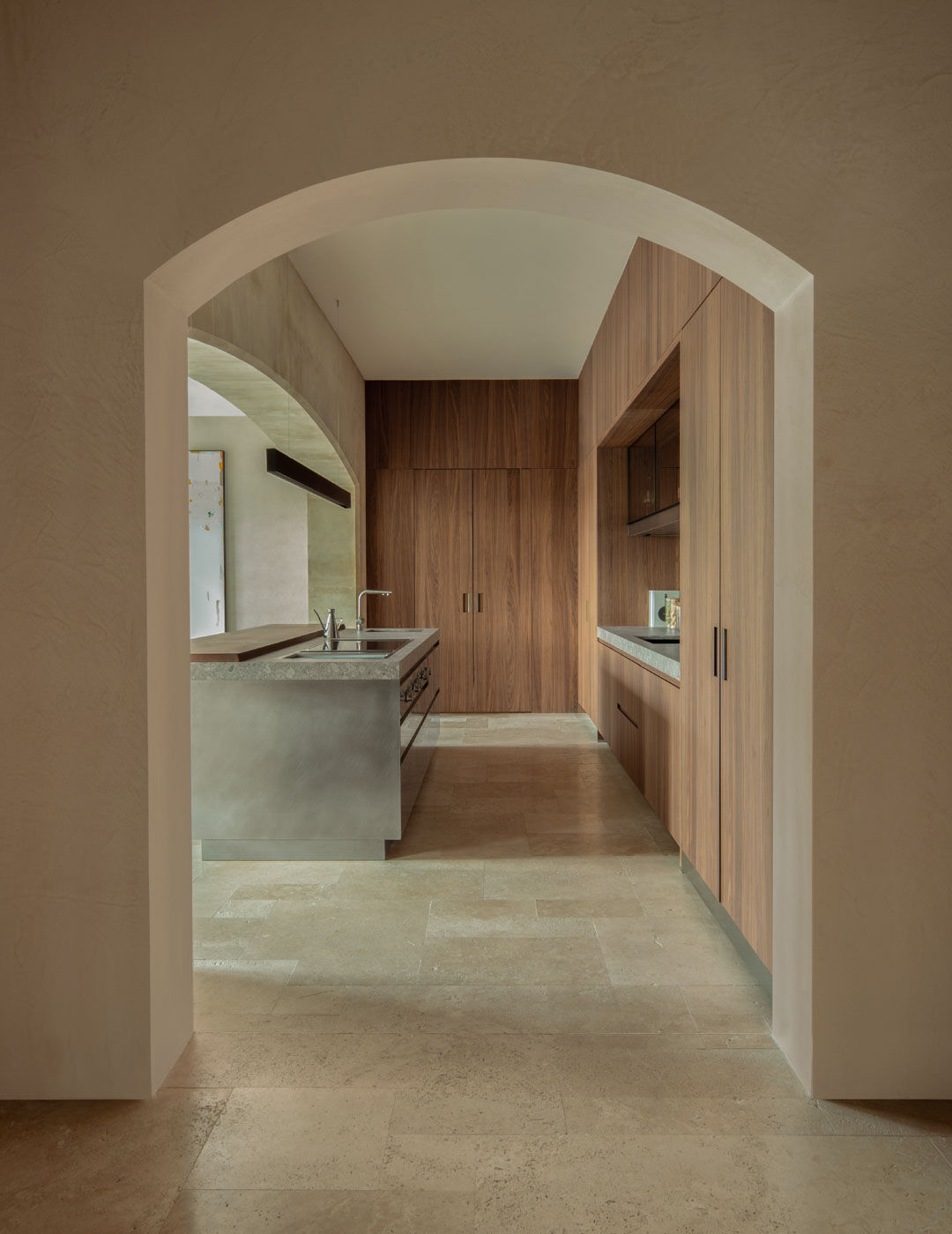 Arclinea kitchen Convivium with arched entry and warm wood cabinetry, minimalist island
