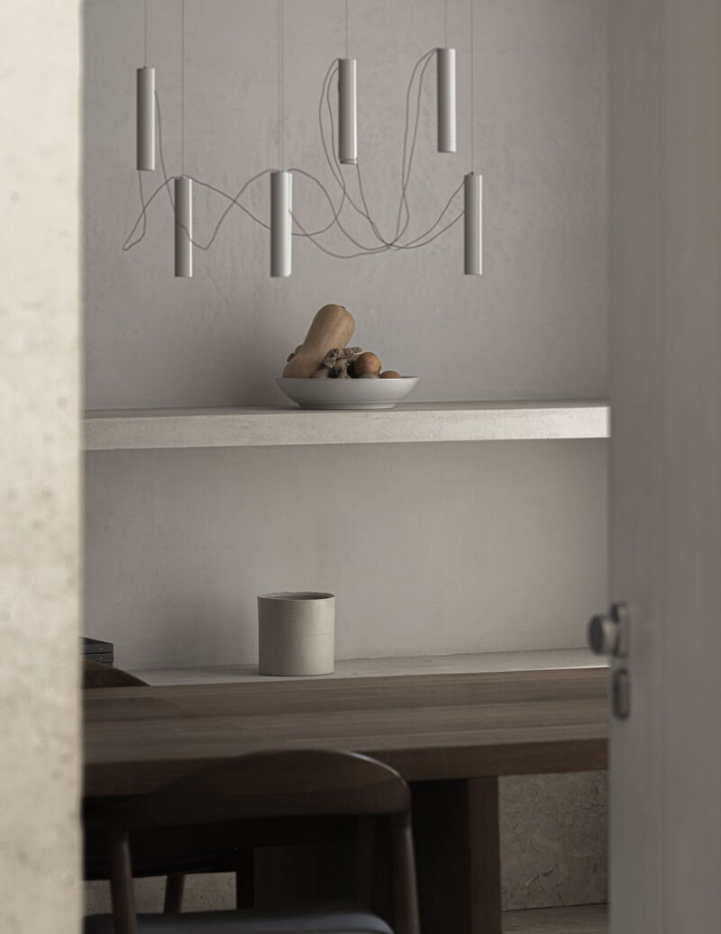 Dining space adjacent to Arclinea Artusi kitchen with sculptural pendant lighting