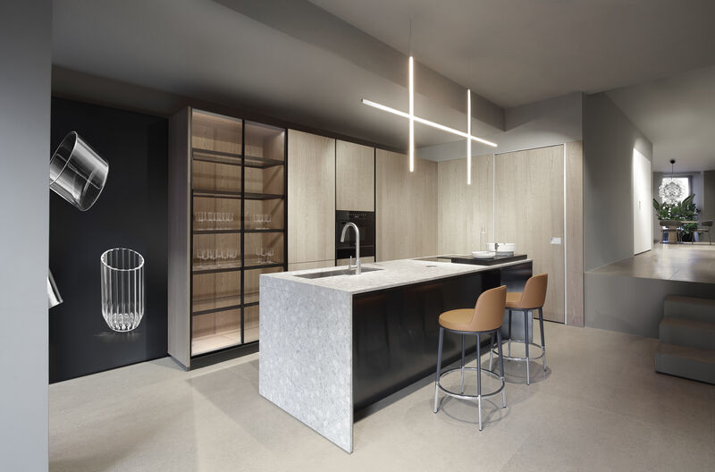 Dark kitchen island with wood cabinetry and glass display shelf